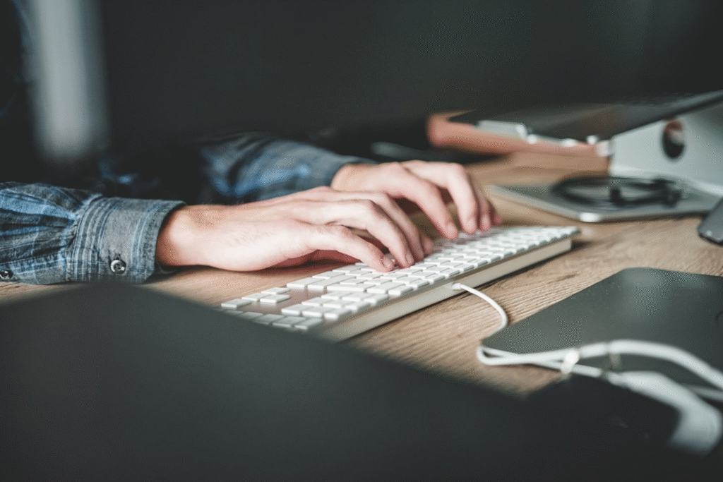 A person typing on a keyboard, focused on evaluating user experience in proposal software selection.